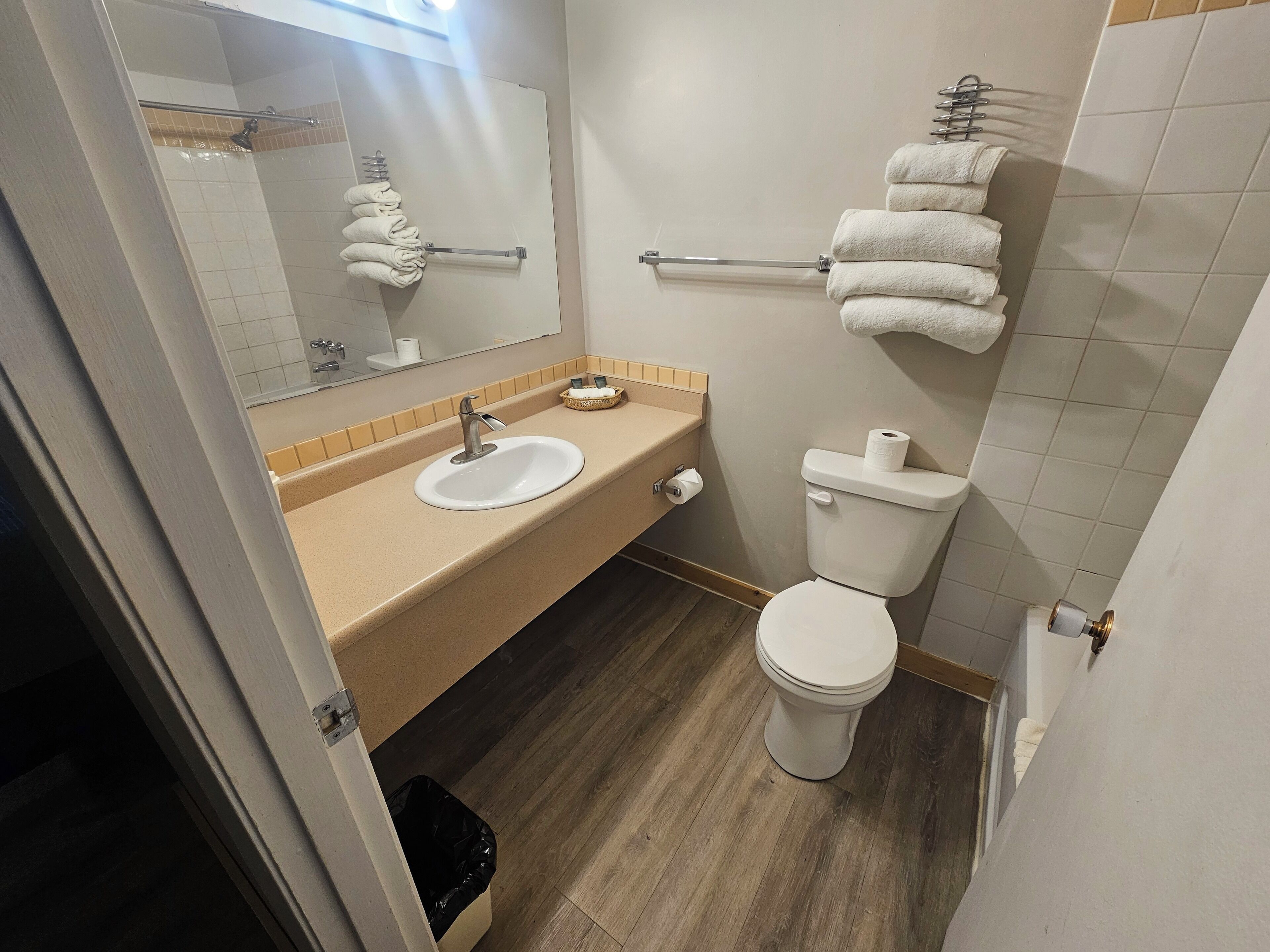 Een badkamer met een wastafel, toilet en handdoekrek.