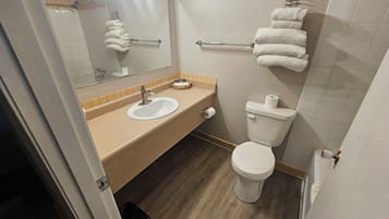 Un baño con lavamanos, inodoro y toallero.