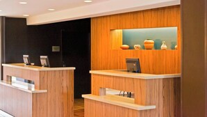 A reception desk with a wooden finish and a small display of decorative vases.