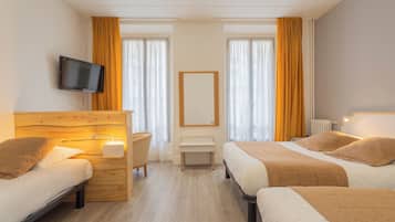 A hotel room with two beds, a TV, a bedside table, a small desk, and a window with curtains.