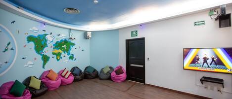 A room with a world map on the wall, bean bags, a television, and a door.