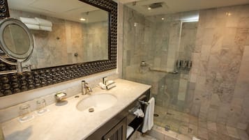 Een moderne badkamer met een grote spiegel, twee wastafels en een douche met glazen wanden.