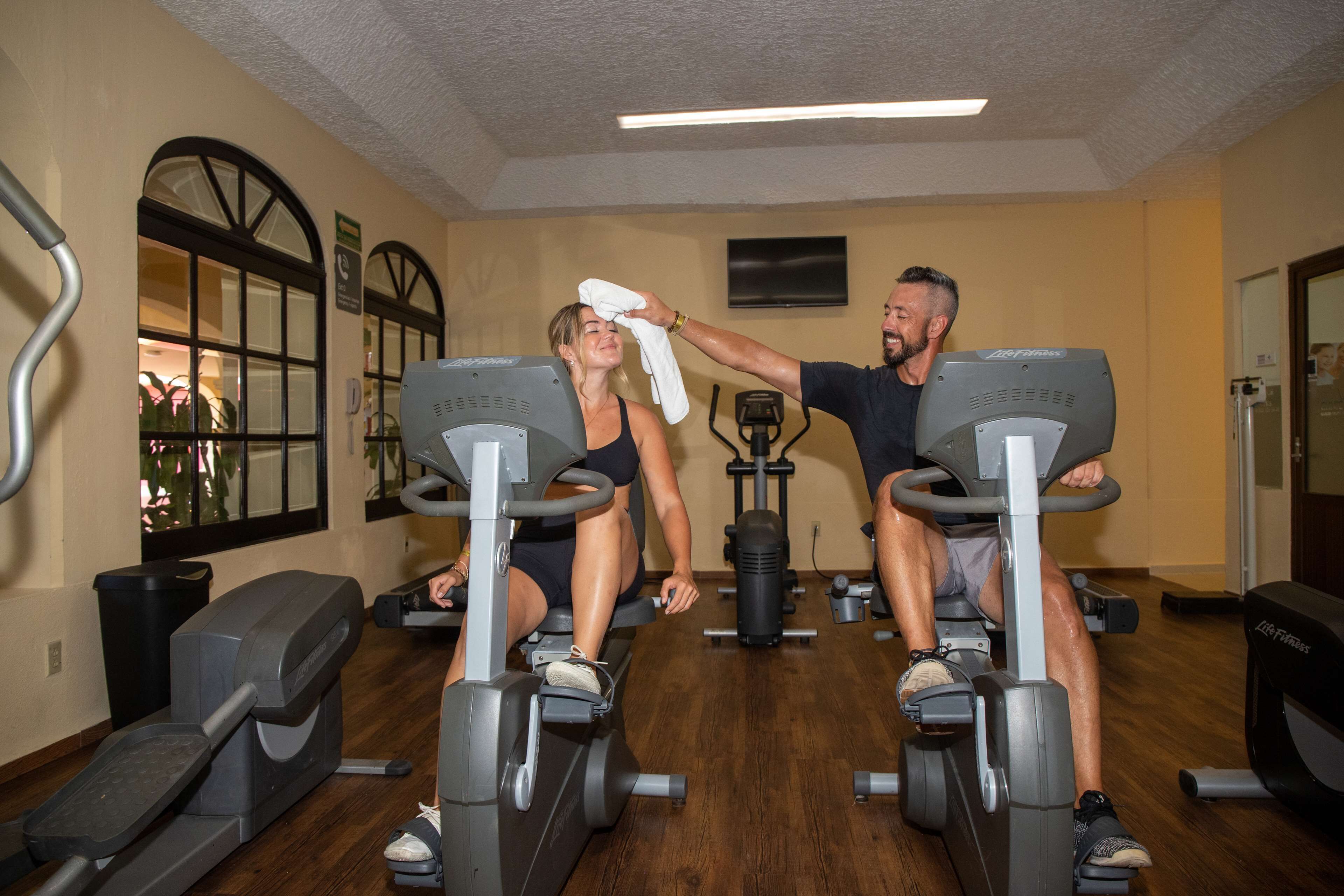 Un gimnasio con bicicletas estáticas, una cinta de correr y equipo de ejercicio.