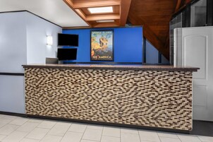 Un mostrador de recepción con diseño de mosaico, un cartel que anuncia el Parque Nacional Apostle Islands y un interior moderno con vigas de madera en el techo.