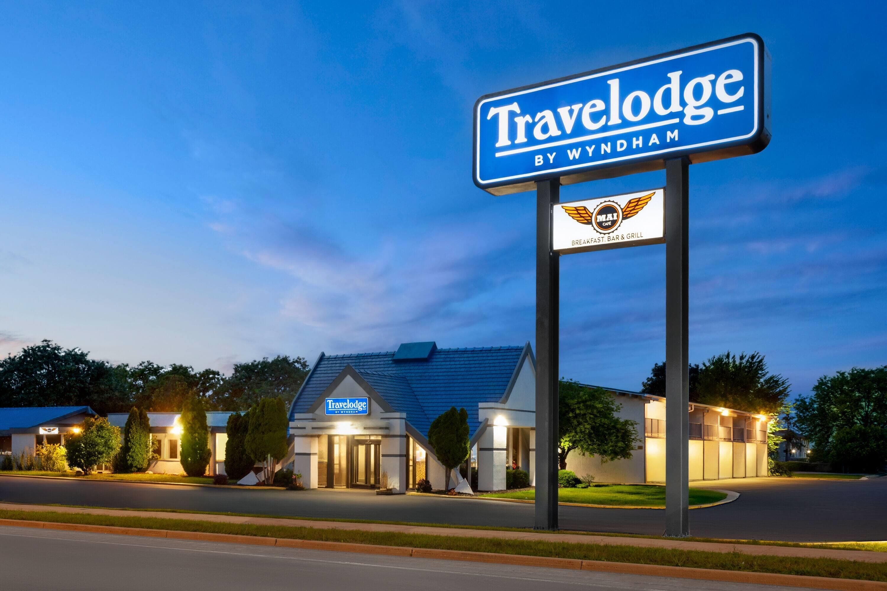 Ein Travelodge Hotel mit Schild, das Wyndham angibt, einer Frühstückstheke und einem Grill.