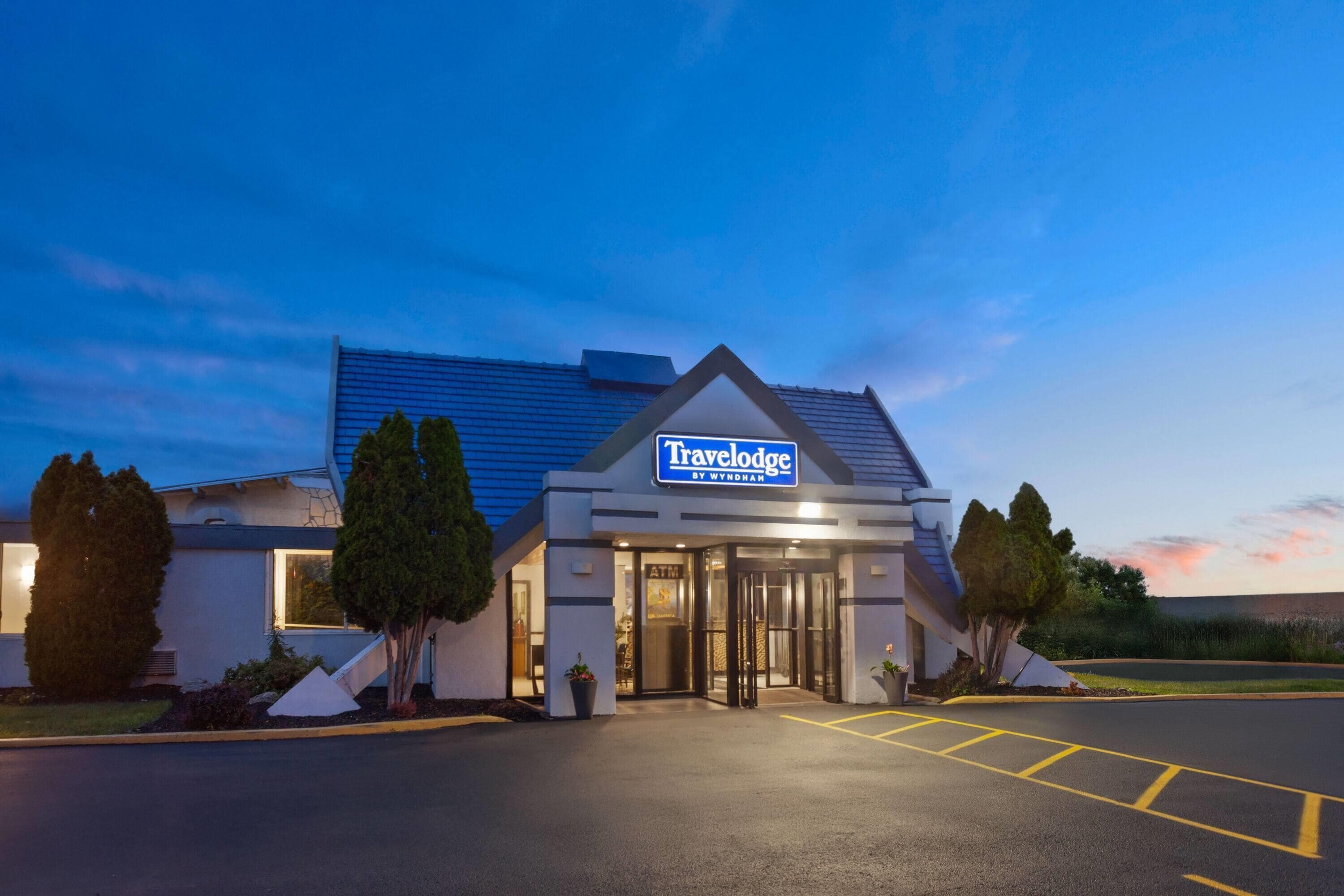 A Travelodge hotel with a modern design, featuring a prominent entrance and a parking area.