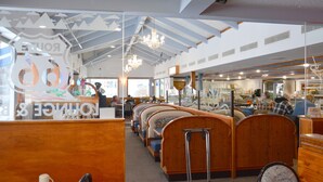 Un restaurante con cabinas de madera, una barra y una araña.