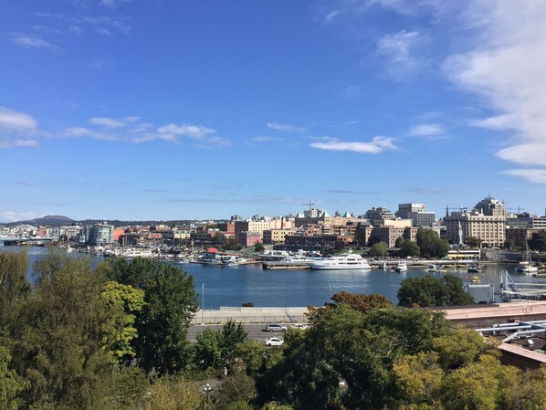 Un paisaje urbano costero con un puerto deportivo, edificios y cielo despejado.