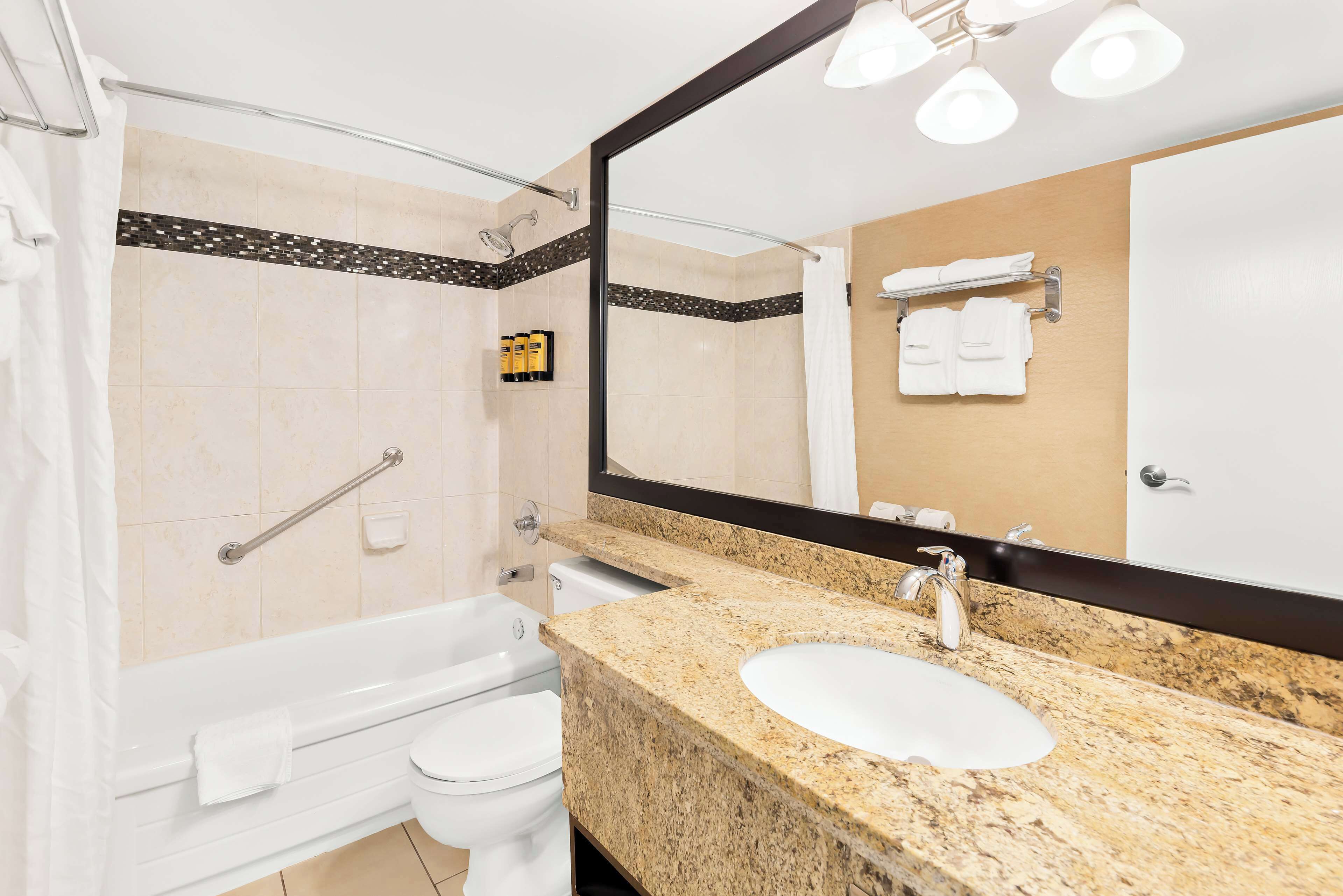 Une salle de bain moderne équipée d’une baignoire, de toilettes et d’un lavabo.