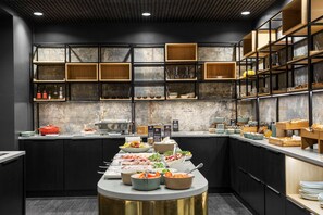 A modern kitchen with a central island, black cabinets, and wooden shelves.
