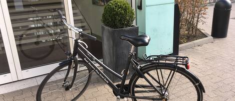 A bicycle parked on a paved area with a building in the background.