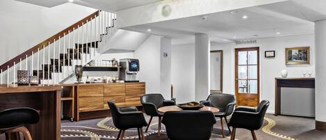Un interior moderno con comedor, cocina y escalera.