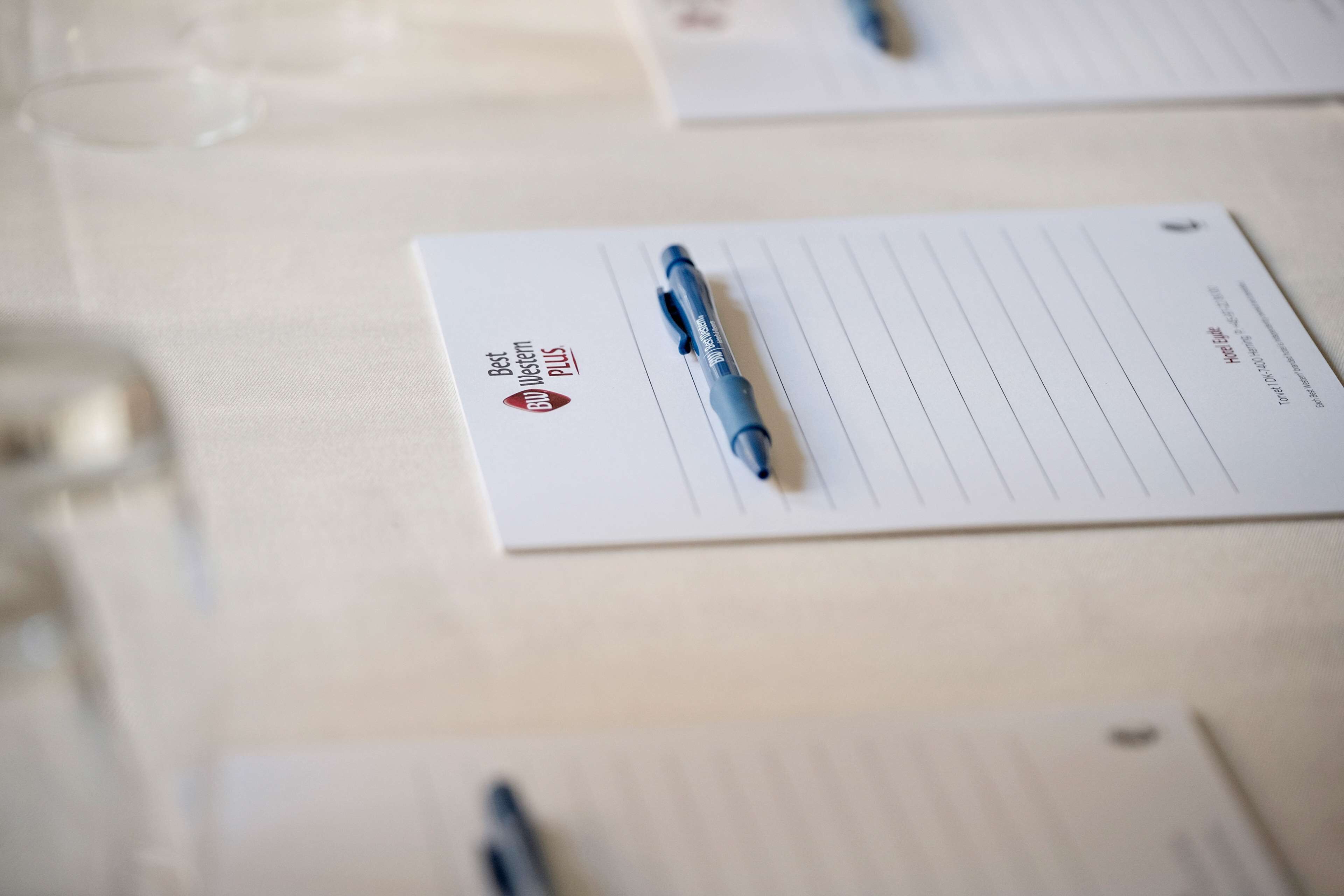 A table with lined notepaper and pens.