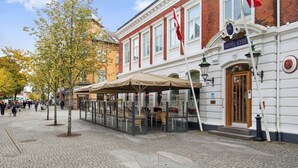A hotel with a classic facade, outdoor seating, and a clear view of the street. - Best Western Plus Hotel Eyde (Herning)