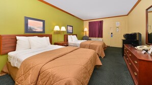 Une chambre d’hôtel avec deux lits, un bureau avec un téléphone, une télévision et deux lampes fixées au mur.