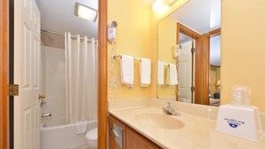 Une salle de bain avec une baignoire, un lavabo, un miroir et une douche.