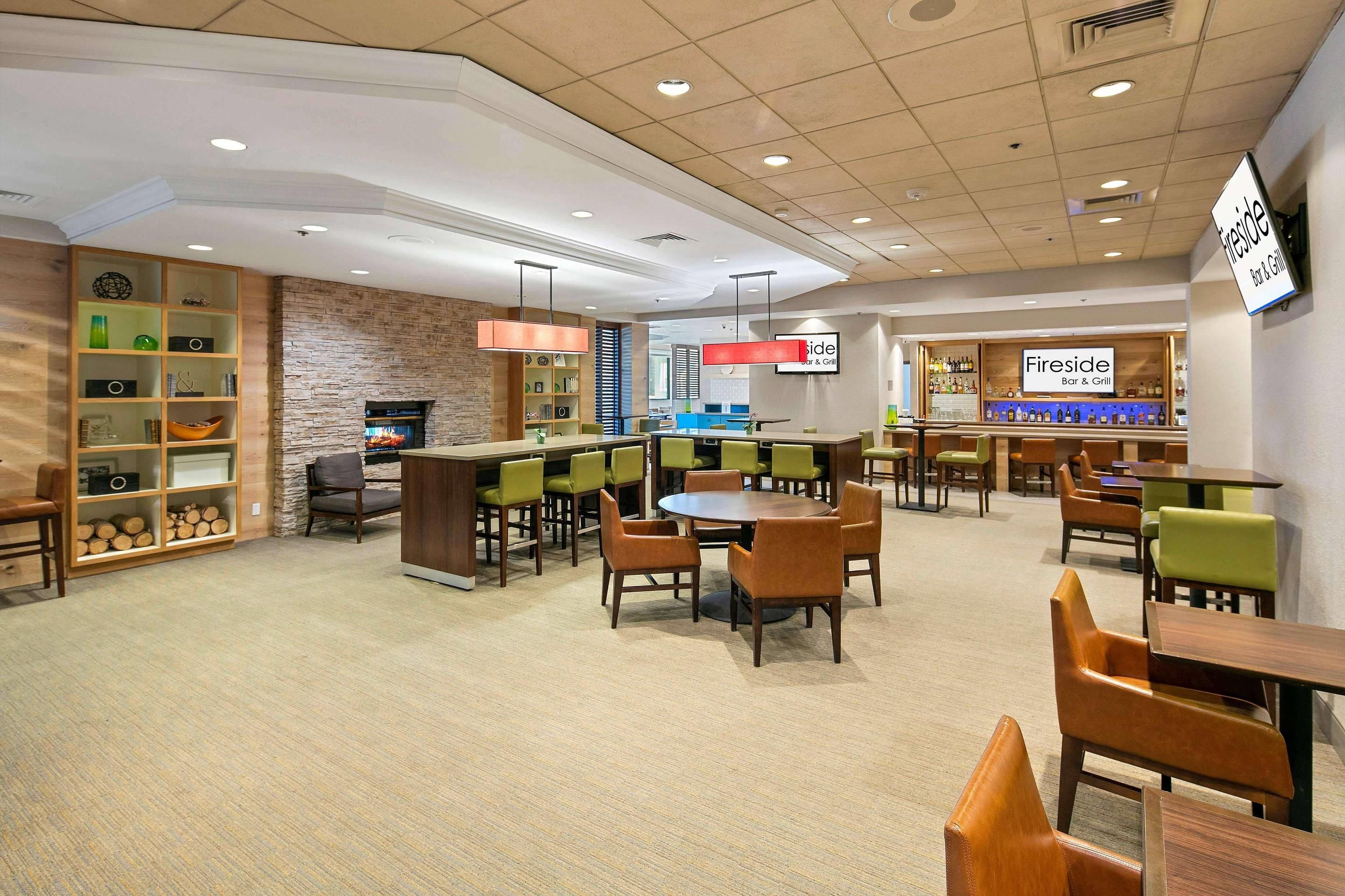 A Fireside Bar & Grill with multiple seating areas, including a bar counter and tables with chairs.