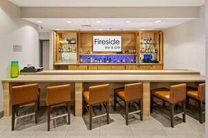 Zona de bar con un cartel que dice 'Fireside Bar & Grill', equipada con una computadora y taburetes de bar.