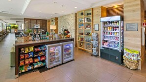 A hotel lobby with a snack bar, refrigerated display cases, and a beverage refrigerator. - Country Inn & Suites by Radisson, San Diego North, CA (San Diego)
