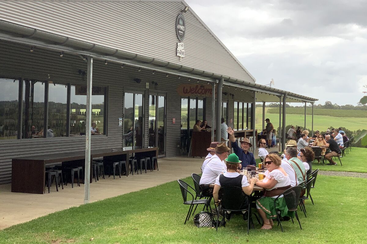 An outdoor dining area with tables and chairs, a covered seating area, and a view of the surrounding landscape.
