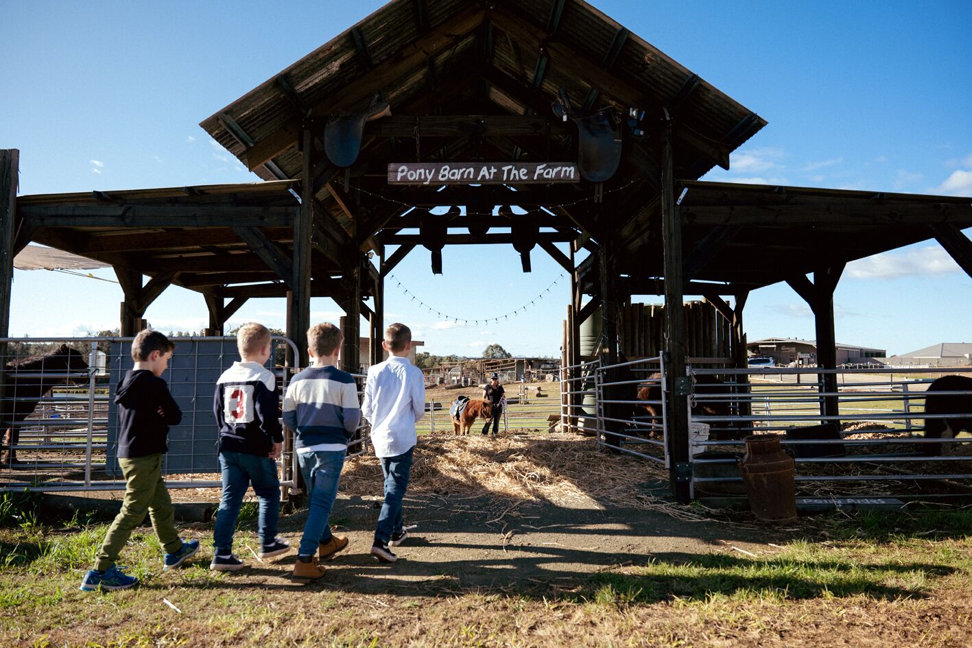 Ein rustikales Bauernhaus mit einem Schild, auf dem 'Pony Barn At The Farm' steht.