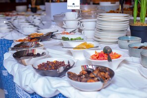 Une table de buffet avec divers plats et ustensiles.