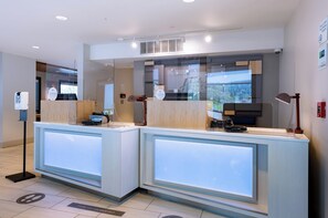 A reception area with two counters, a hand sanitizer dispenser, and a fire alarm. - Holiday Inn Express Mill Valley San Francisco Area by IHG (Mill Valley)