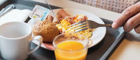 A tray with breakfast items including eggs, toast, and orange juice.