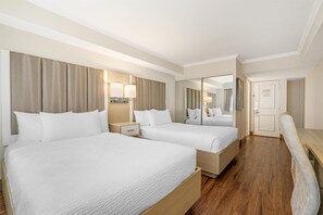 A hotel room with two beds, a nightstand, a mirror, and a wooden floor. - Best Western Dorchester Hotel (Nanaimo)
