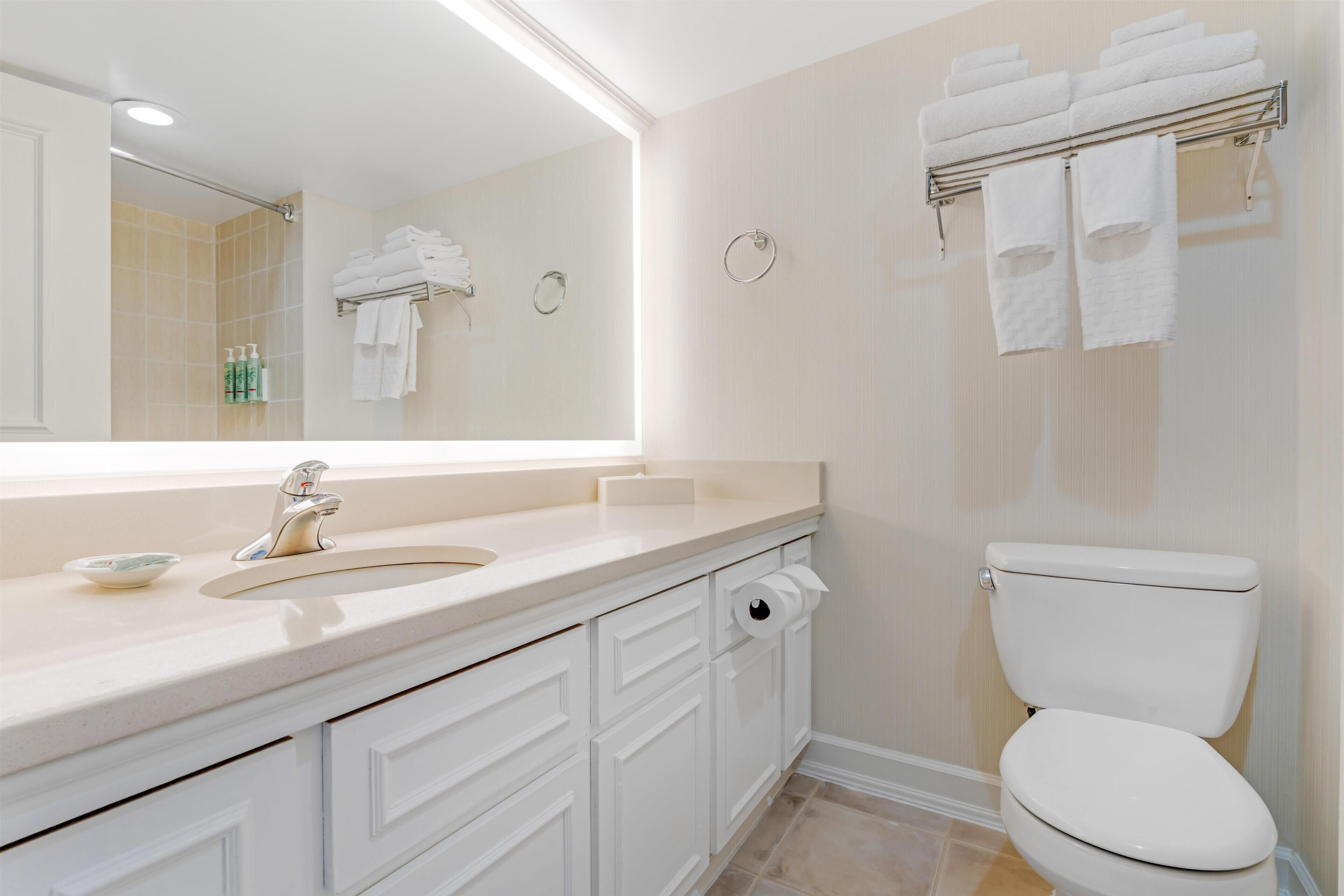 Une salle de bain équipée d’un lavabo, de toilettes et d’un porte-serviettes.
