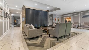 Un hall d’entrée moderne avec un canapé, un fauteuil et une table basse.