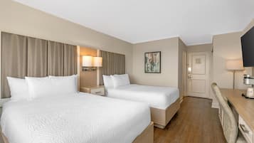 Une chambre d’hôtel avec deux lits, un bureau, une chaise, une télévision et une porte.