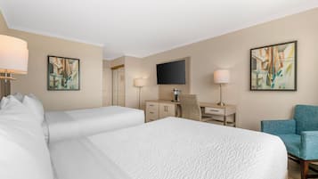 A hotel room with a large bed, a desk, a chair, a TV, and artwork on the walls.