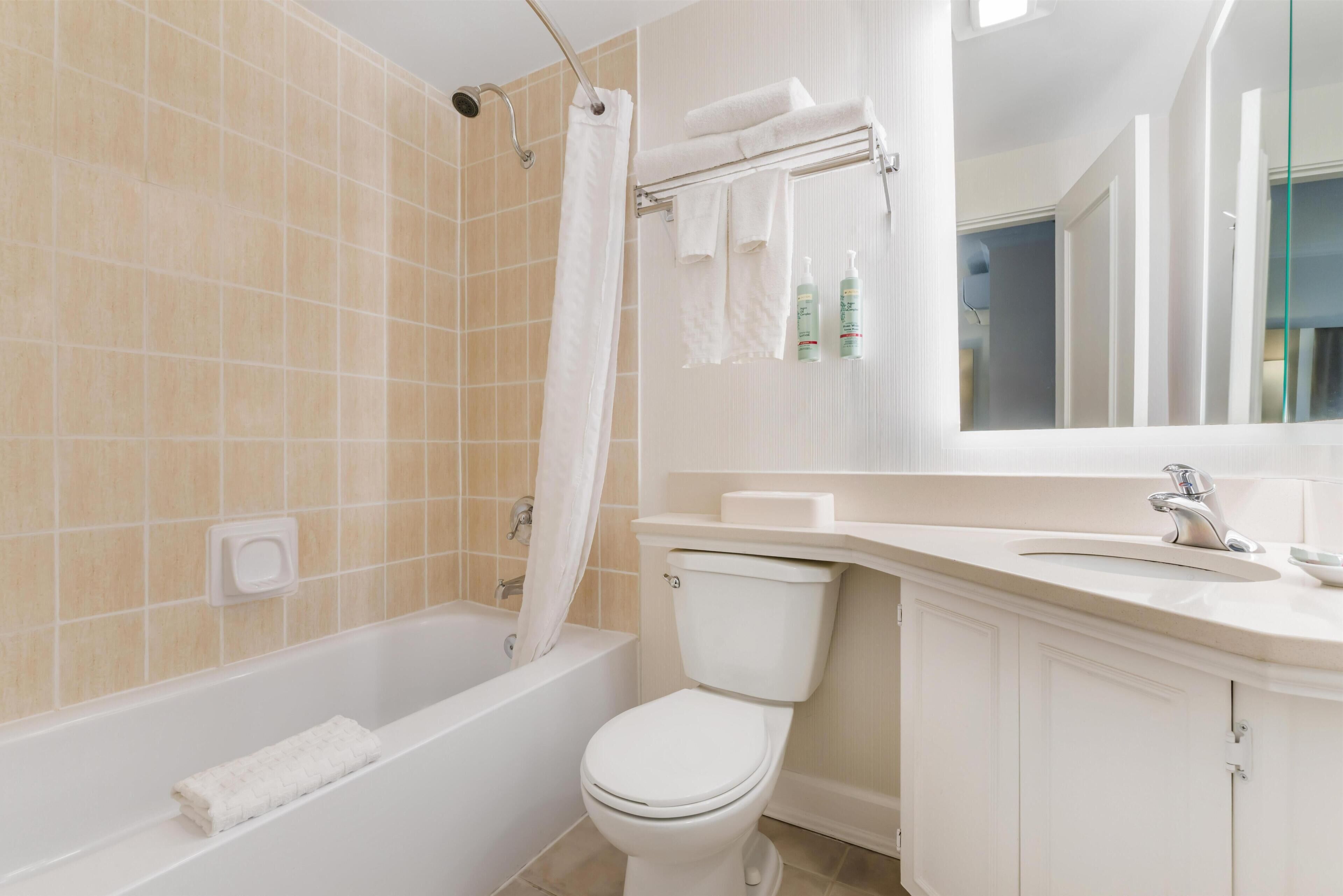 A bathroom with a bathtub, toilet, and sink.
