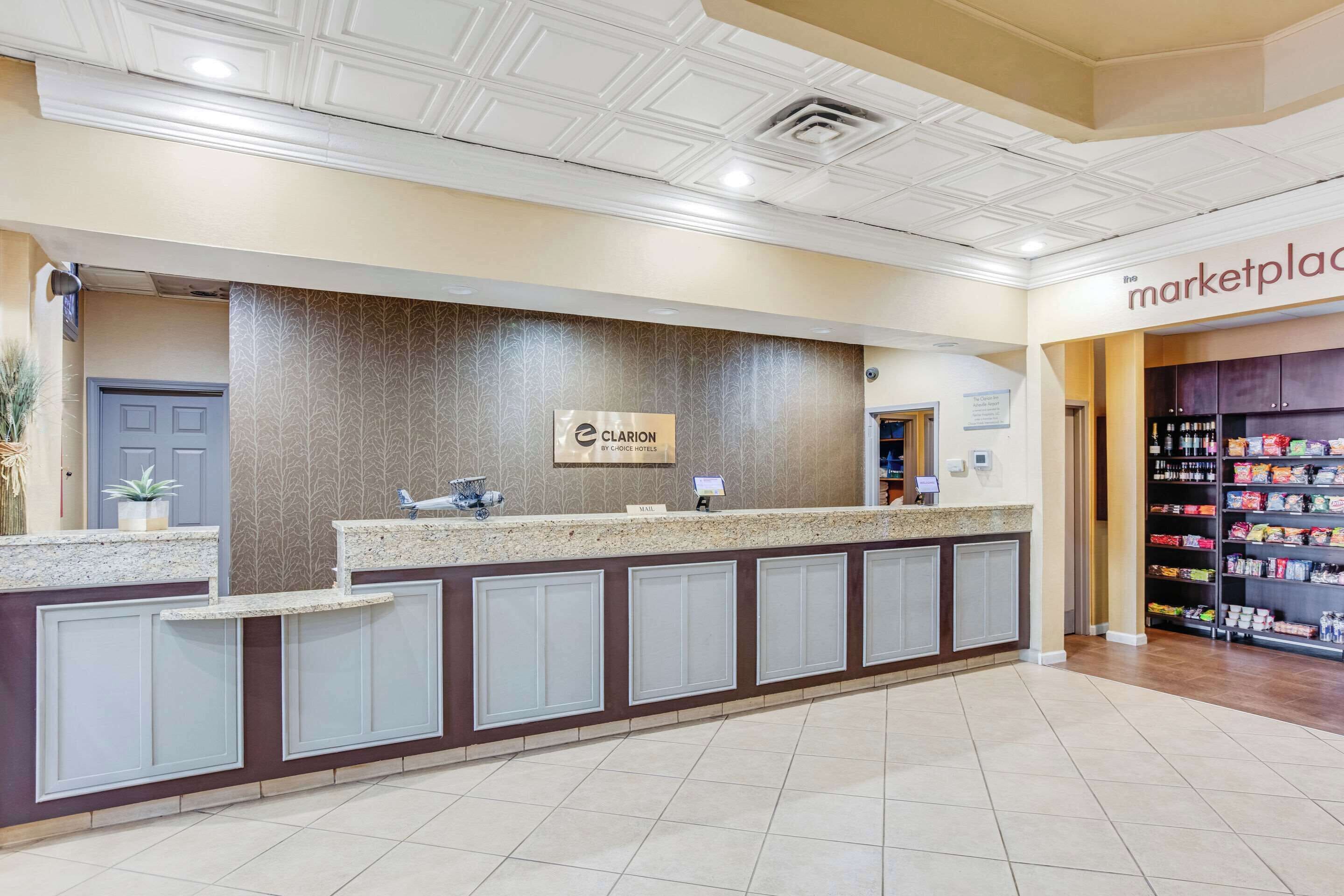 A hotel reception area with a marble counter, a sign for 'Clarion Hotel', and a 'marketplace' sign in the background.