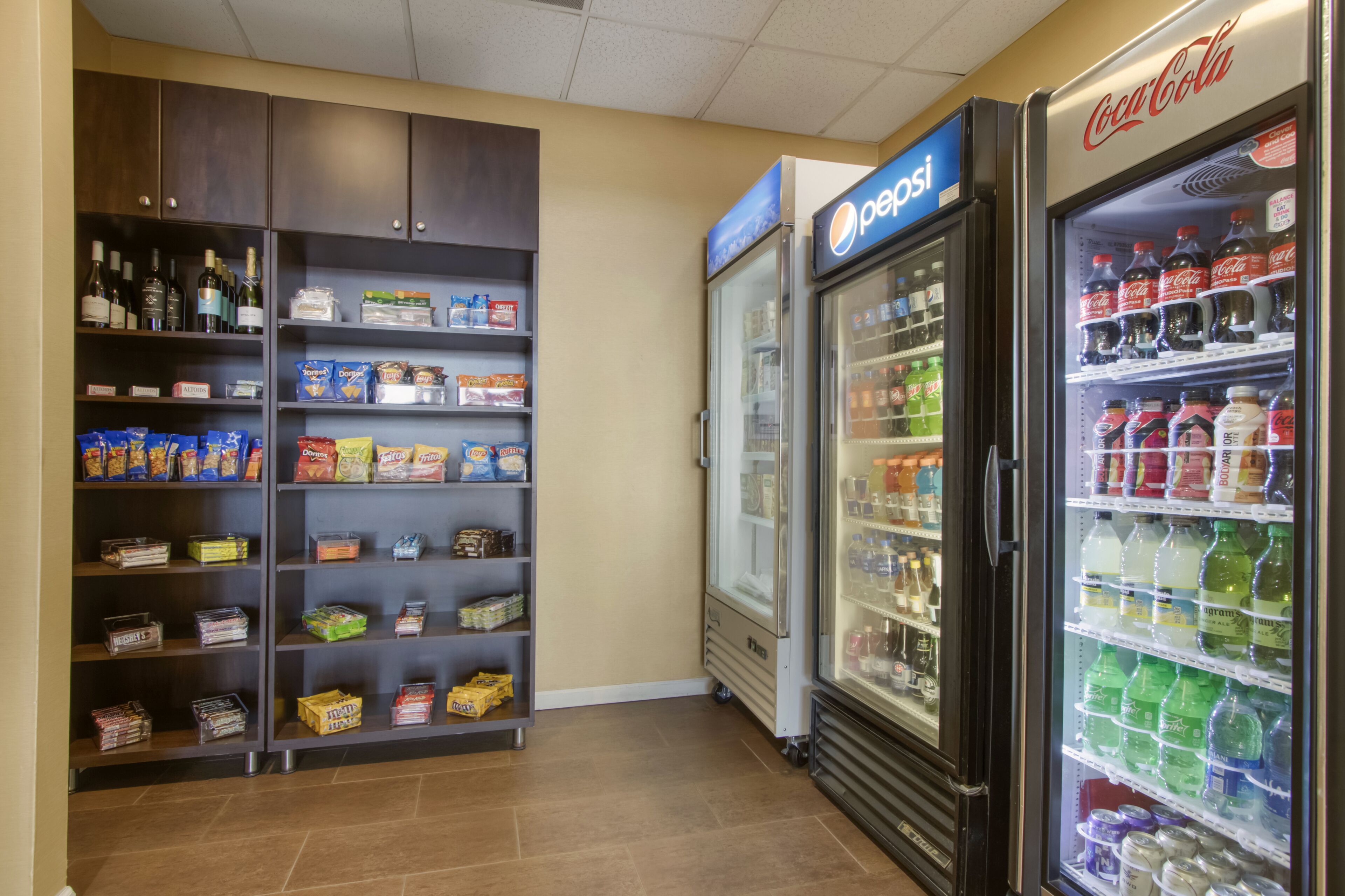 Una zona de venta con refrigeradores de Pepsi y Coca-Cola, además de dispensadores de aperitivos y bebidas, y otro refrigerador de Pepsi.