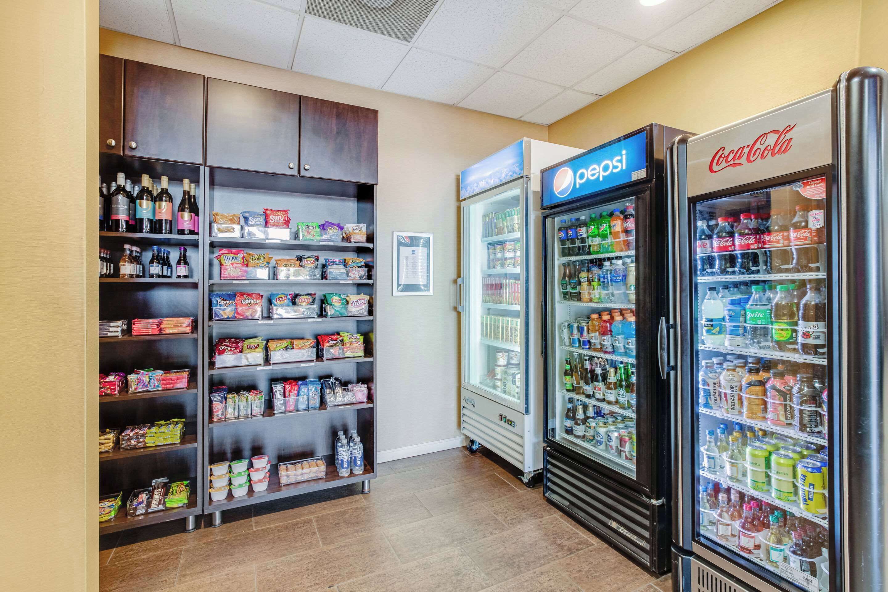 A vending area with Pepsi and Coca-Cola refrigerators, snack shelves, and a variety of beverages.