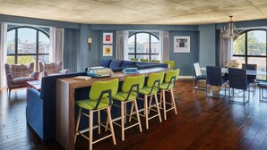 A modern kitchen with a central island, bar stools, and a dining area with chairs. - Graduate by Hilton Oxford (Oxford)