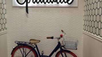 A hallway with a wall-mounted sign that reads "Graduate" and a bicycle parked against the wall.
