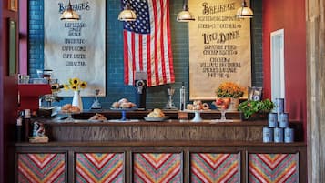 Mostrador de cafetería con un menú, una bandera estadounidense y diversas opciones de repostería.
