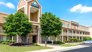 A Days Inn hotel with a central entrance, multiple balconies, and a parking area. - Days Inn by Wyndham Florence Cincinnati Area (Florence)