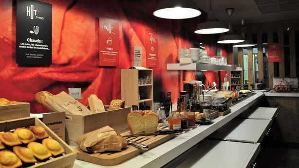 A buffet area with bread, pastries, and condiments.