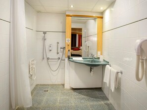 Une salle de bain avec une douche, un lavabo et un miroir.