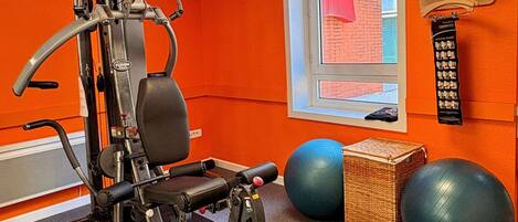 A gym with exercise equipment, a window with a 'DIS' sign, and exercise balls.