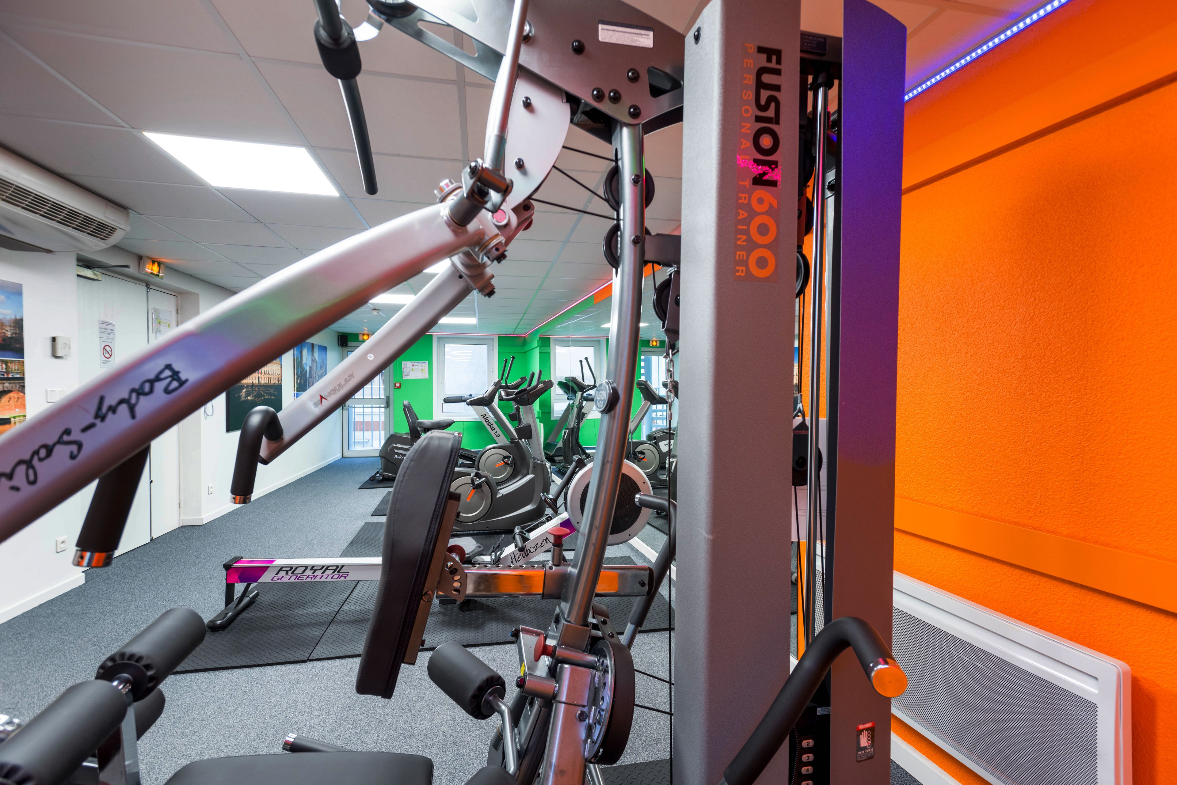 A gym with exercise equipment, including a rowing machine and a stationary bike.