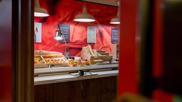 A bakery display with various baked goods and a menu board.