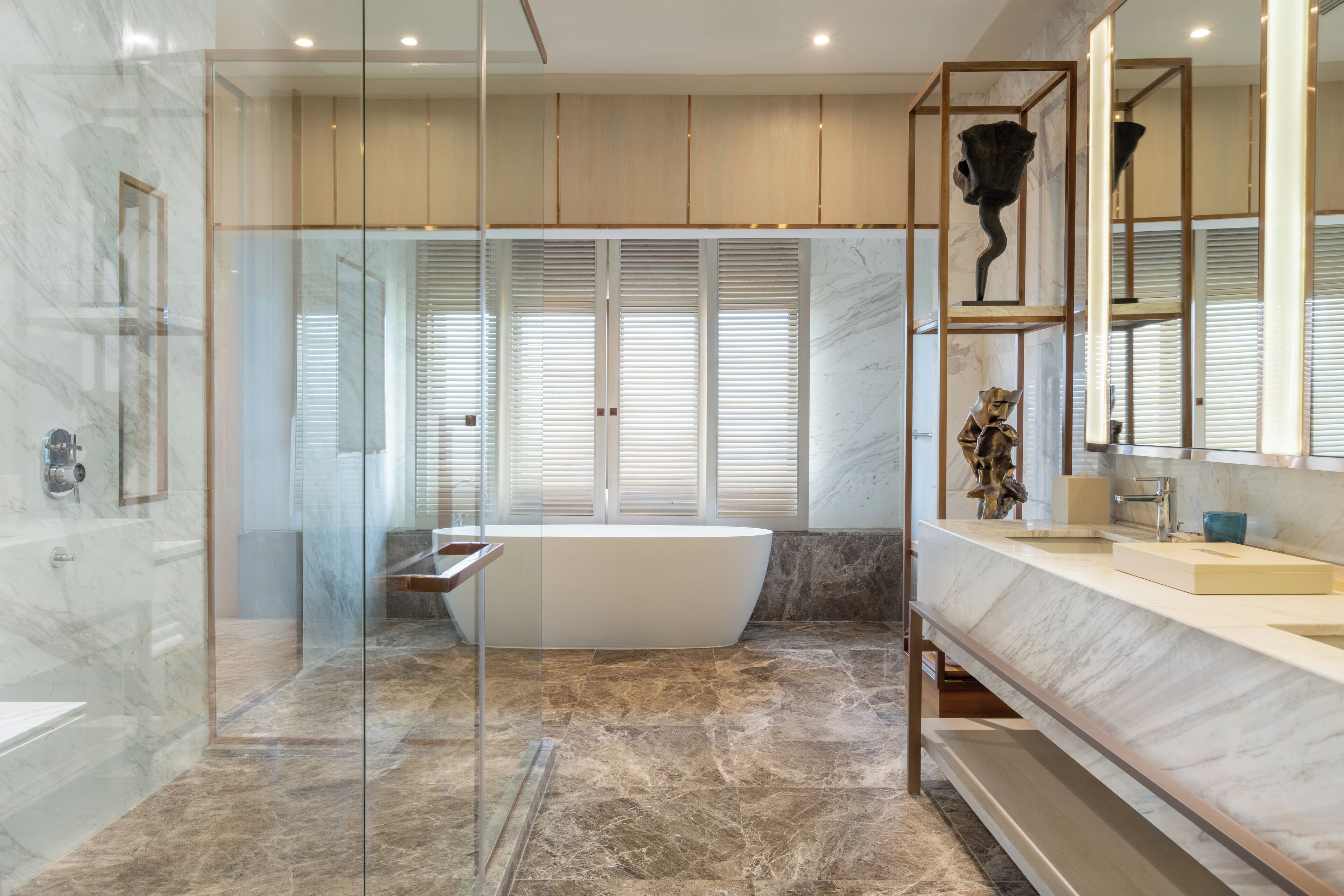 A modern bathroom with a freestanding bathtub, a large vanity with a mirror, and a glass-enclosed shower area.