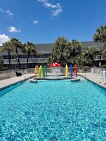 Una piscina al aire libre de temporada, sombrillas