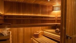 A wooden sauna with benches and a bench with a towel. - A-Hotel Oosterhout (Oosterhout)