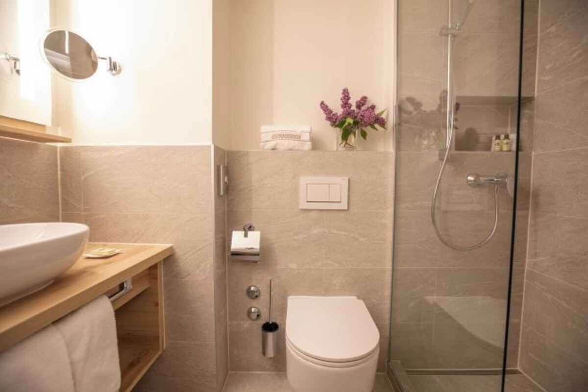Een moderne badkamer met een groot wastafel, toilet en douche.